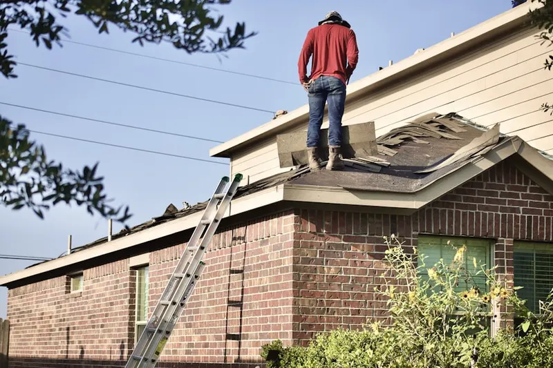 Professional roofer working on a residential roof in University Square